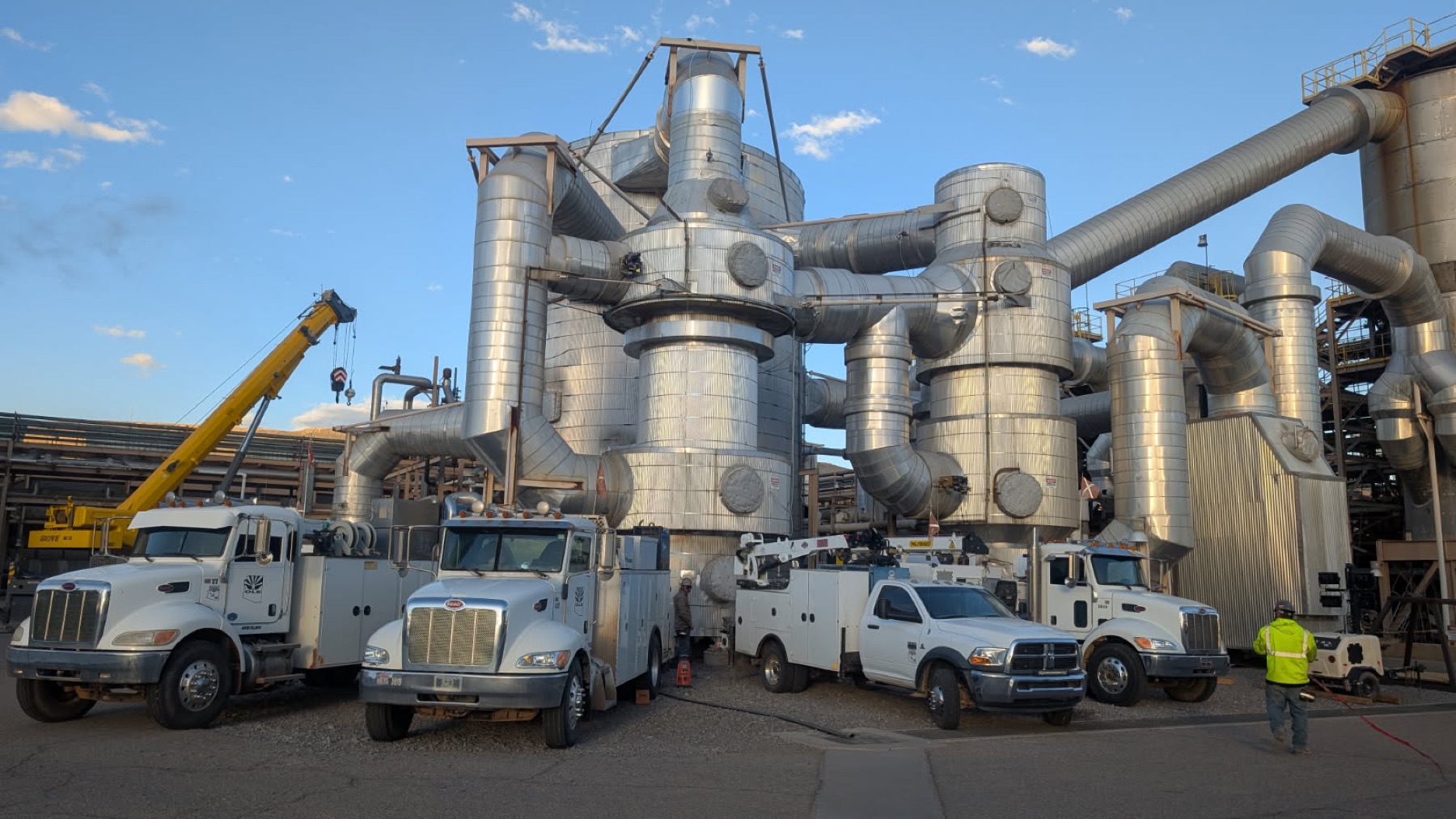 IMM service trucks staged at an acid plant project site